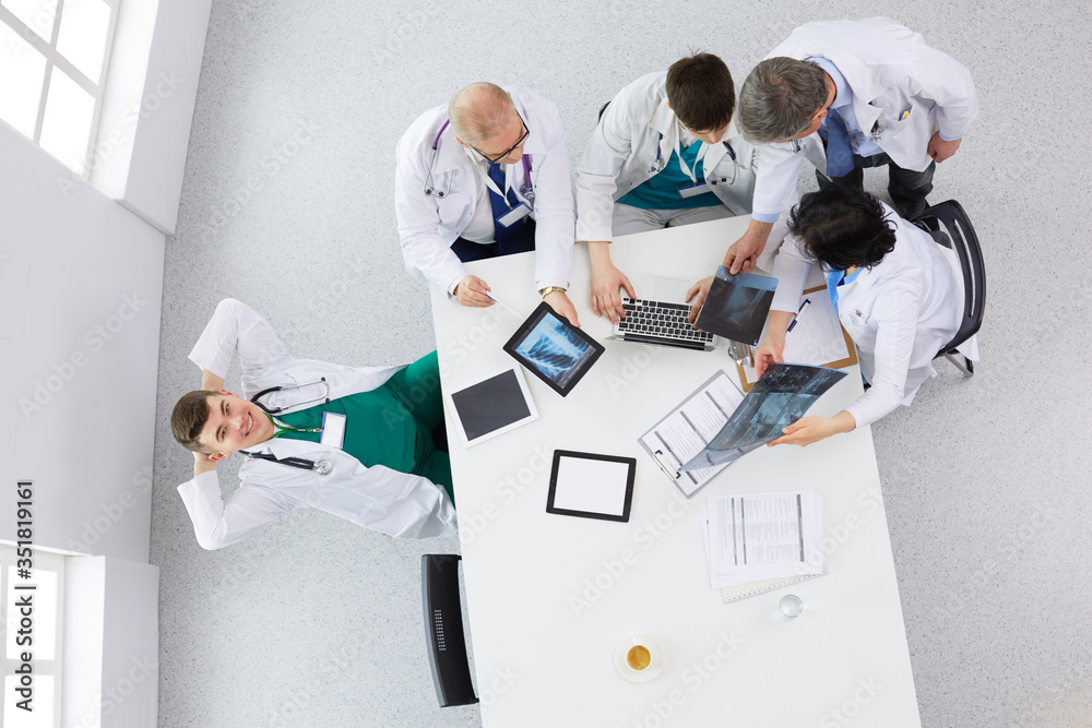 Obraz premium Medical team sitting and discussing at table, top view
