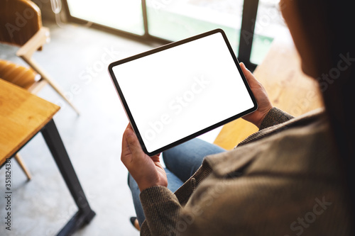 Top view mockup image of a woman holding black tablet pc with blank white desktop screen