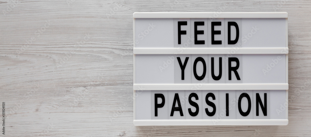 'Feed your passion' words on a lightbox on a white wooden background, top view. Overhead, from above, flat lay. Copy space. 'Feed your passion' words on a lightbox on a white wooden background, top view. Overhead, from above, flat lay. Copy space.