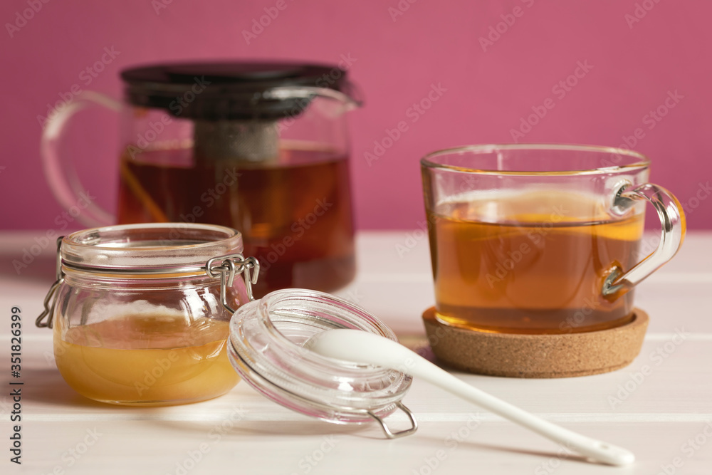 Honey in glass pot and cup of black tea with lemon. Healthy eating concept. Honey in glass pot and cup of black tea with lemon. Healthy eating concept.