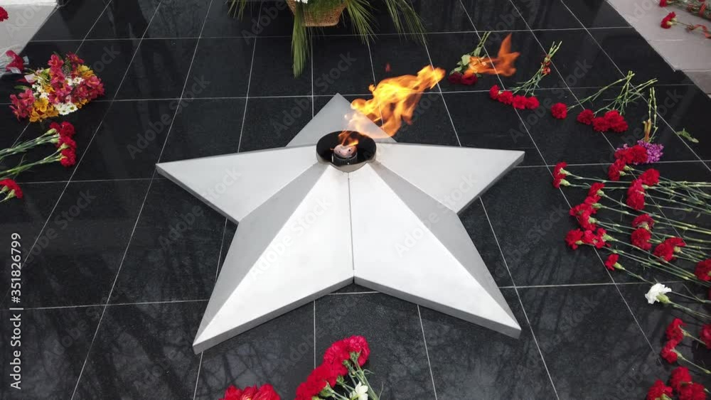 Red flowers lay near eternal fire on memorial of Second World War ...
