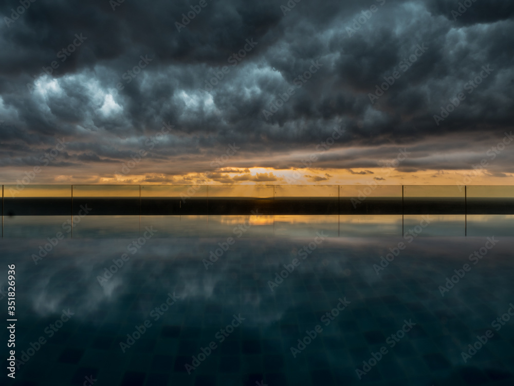 Perfect wallpaper image of reflections of storm clouds in infinity pool water on rooftop bar colombo