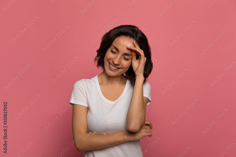 Beauty secrets. Close-up photo of a modern young woman in a white t-shirt, who is smiling with her eyes closed, while touching her forehead with her left hand. Beauty secrets. Close-up photo of a modern young woman in a white t-shirt, who is smiling with her eyes closed, while touching her forehead with her left hand.