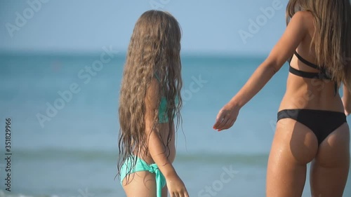 mom and daughter go by the sea