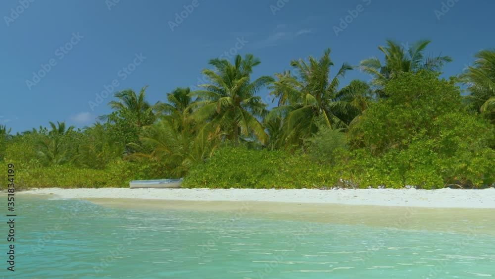 Old boat is left stranded in the greenery of a remote tropical island in the Maldives. Idyllic shot of a turquoise colored sea washing the beautiful white sand shore of a remote exotic island in Asia. Old boat is left stranded in the greenery of a remote tropical island in the Maldives. Idyllic shot of a turquoise colored sea washing the beautiful white sand shore of a remote exotic island in Asia.