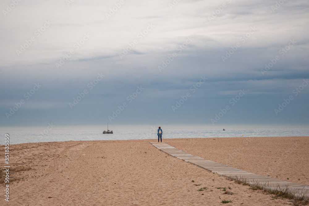 Man looks at the sea with a boat.