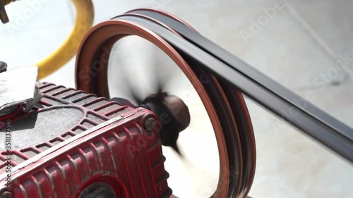 Closeup rotating pulley and belt on air pump machine