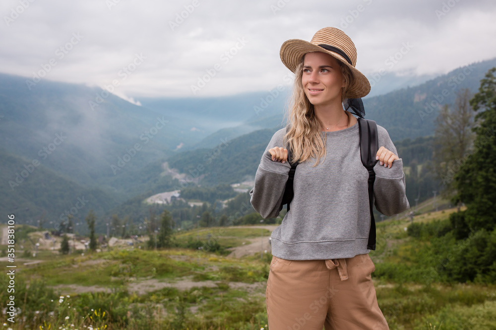 Side view slim young caucasian girl walks on top of mountain. Youth and discovery, thirst for travel. Female Student Blogger Enjoys Mountain Vacation. Togetherness With Nature And Relaxation Concept