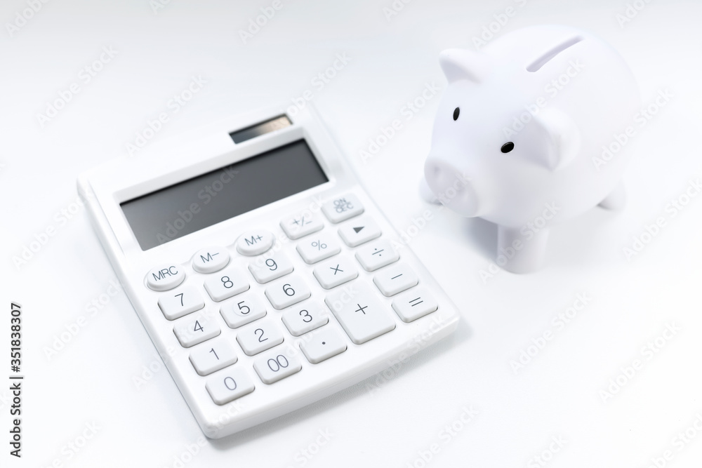 White calculator and white piggy on white background. Financial bookkeeping, Accounting Concept. Top view. White calculator and white piggy on white background. Financial bookkeeping, Accounting Concept. Top view.