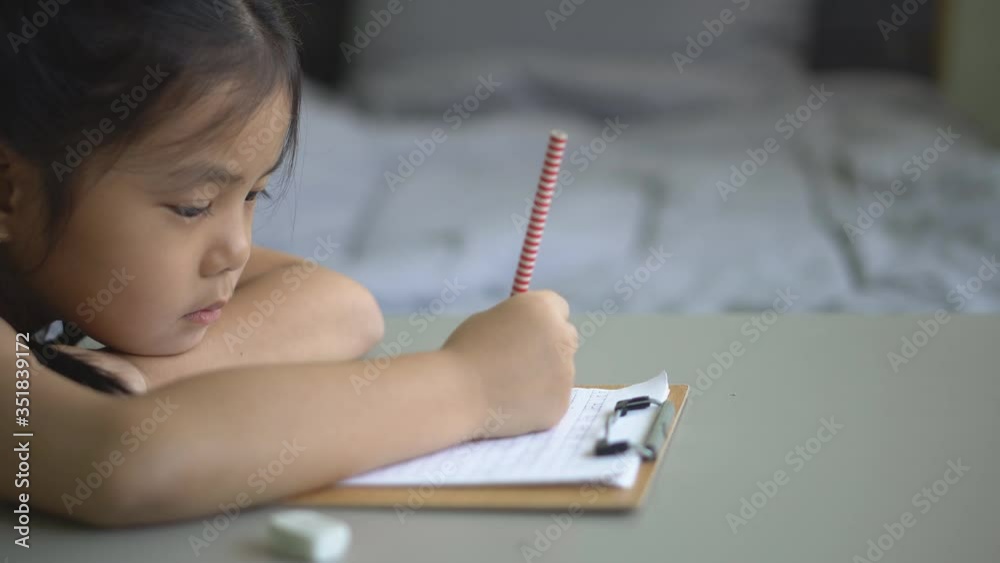 asian child student or kid girl smile writing drawing and enjoy doing homework or happy read learn and training write on paper with table by stay home safe and kindergarten study online in bedroom 4K asian child student or kid girl smile writing drawing and enjoy doing homework or happy read learn and training write on paper with table by stay home safe and kindergarten study online in bedroom 4K