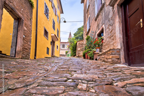 Buje. Old adriatic town of Buje stone street and church view photo