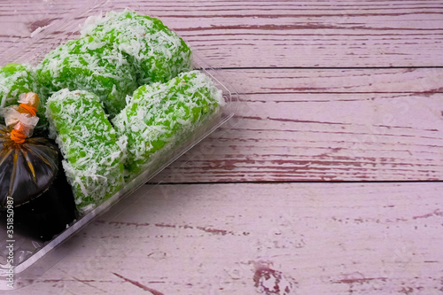 Top view glutinous rice cooked in pandan (screwpine leaves) juice, coat with  slightly salted coconut shavings). Served with brown sugar syrup. (Malay : lopis) photo