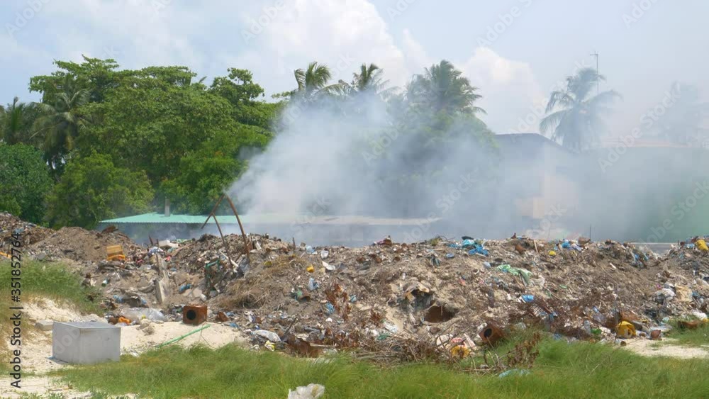 Landfill full of dirty garbage is burning waste in the middle of a