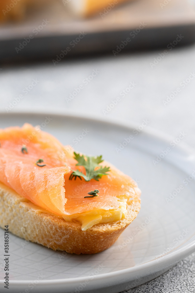 Bruschetta with smoked salmon and butter on concrete background. Delicious snack or appetizer.Close up Bruschetta with smoked salmon and butter on concrete background. Delicious snack or appetizer.Close up