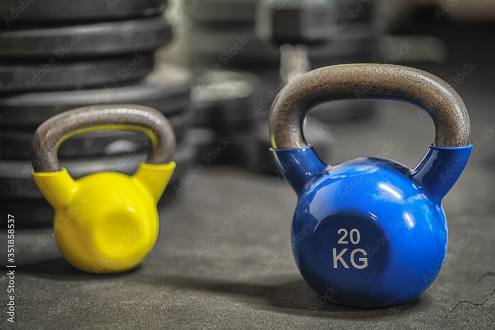 Blue and yellow colorful kettlebell weights in the gym Blue and yellow colorful kettlebell weights in the gym