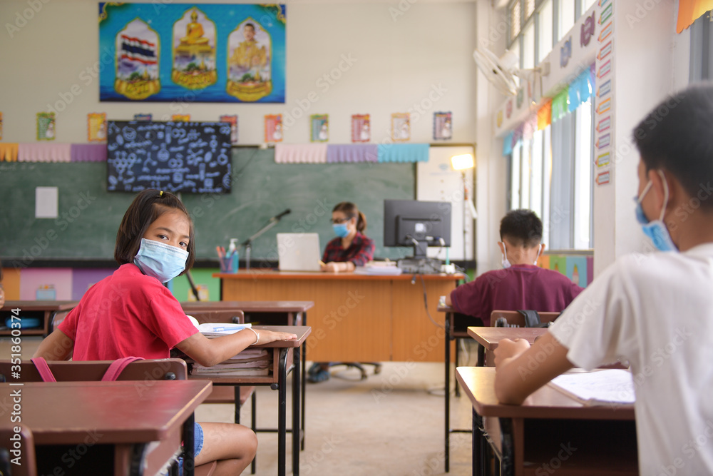 school kids with protection face mask against flu virus at lesson in classroom school kids with protection face mask against flu virus at lesson in classroom