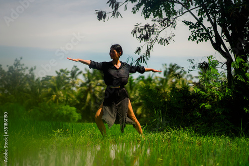 outdoors yoga and meditation at rice field - attractive and happy middle aged Asian Japanese woman enjoying yoga and relaxation in connection with the nature