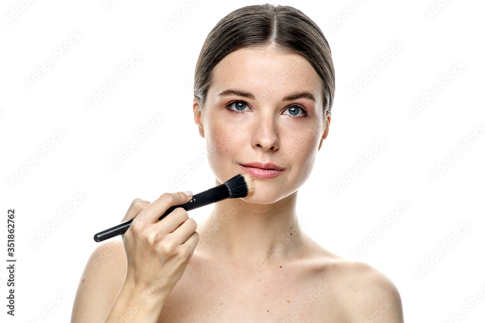 close-up portrait of a girl without makeup with clean skin with a makeup brush in hand, isolated on a white background close-up portrait of a girl without makeup with clean skin with a makeup brush in hand, isolated on a white background