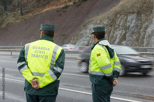 Guardia Civil officer watch traffic on a highway on a rainy day