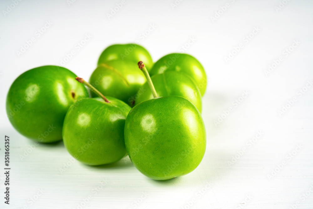 Close-up macro fresh green sour plum. Greengage on white background. Close-up macro fresh green sour plum. Greengage on white background.