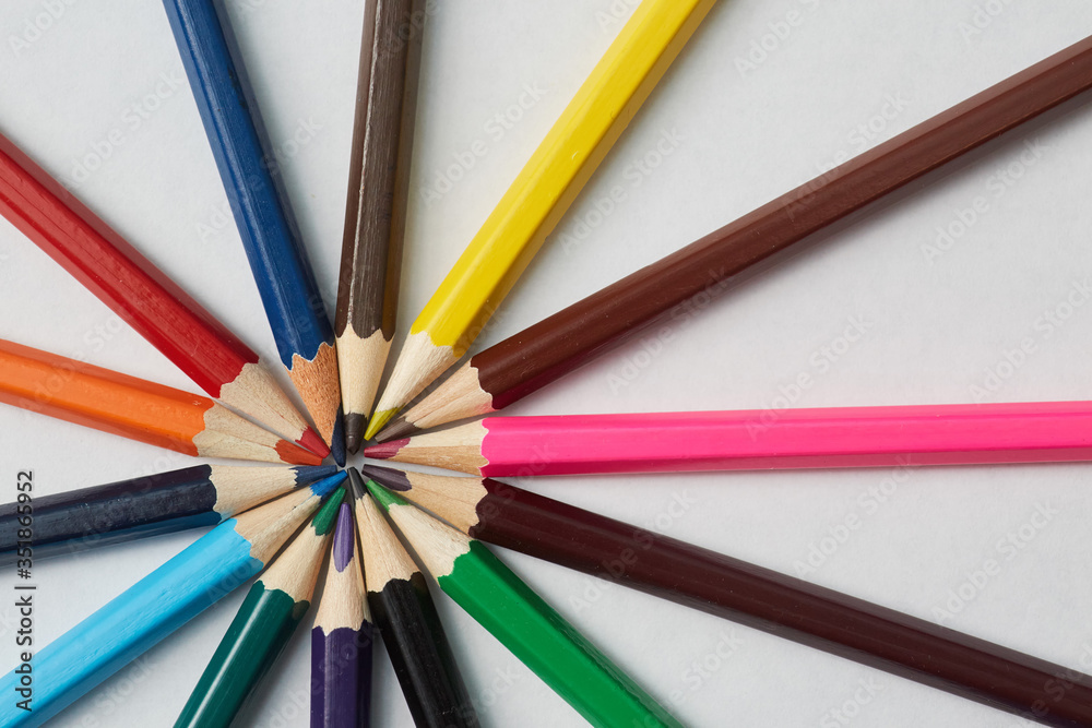 Several colored pencils of various shades lie on a white background, macro photography. Several colored pencils of various shades lie on a white background, macro photography.