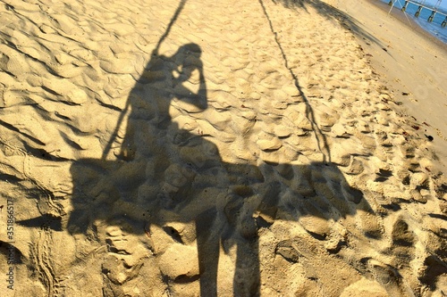 The shadow on the swing at the beach.