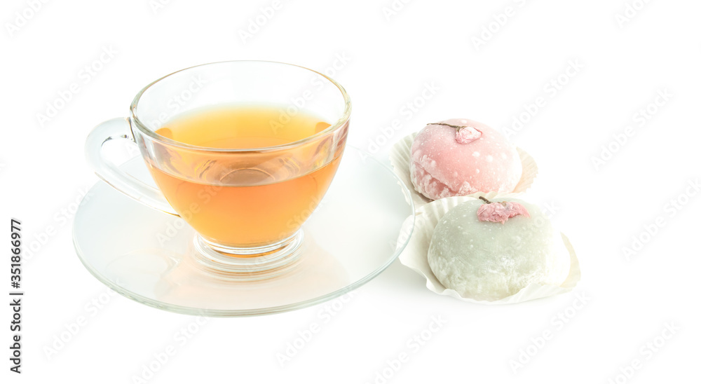 Tea cup transperent glass and snack japanese name Daifuku Mochi pink cherry blossoms,isolated on white background. Tea cup transperent glass and snack japanese name Daifuku Mochi pink cherry blossoms,isolated on white background.