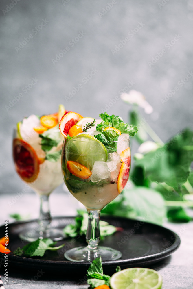 Lemonade with orange, lime, kumquat and mint in a glass Lemonade with orange, lime, kumquat and mint in a glass