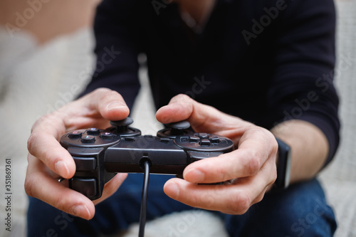 A man plays video games with a joystick in his hands