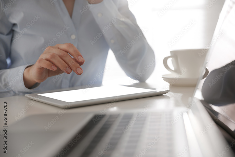 Businesswoman working with modern tablet at table in office, closeup Businesswoman working with modern tablet at table in office, closeup