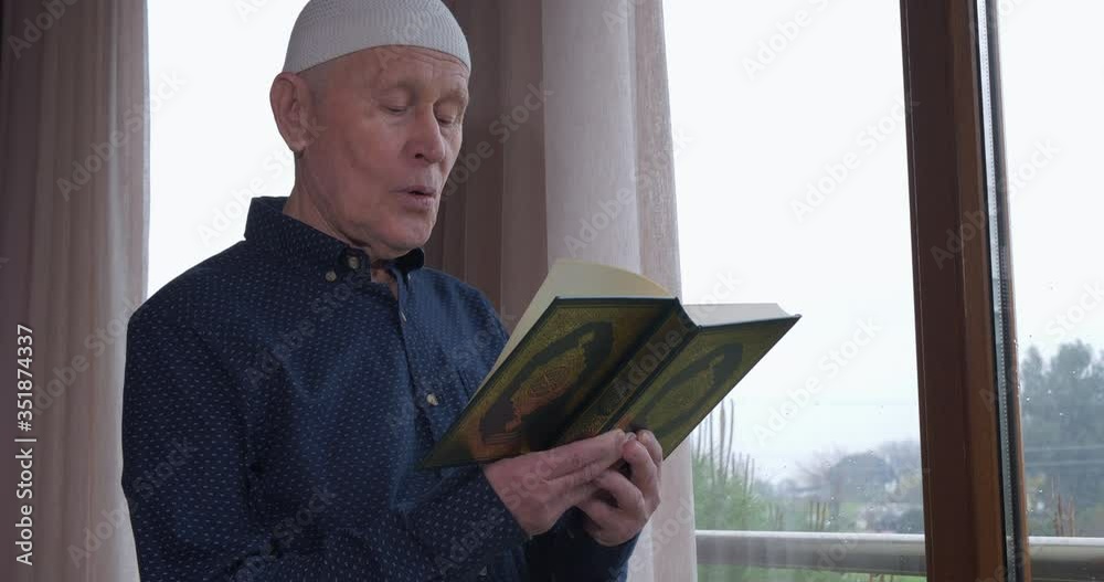An old muslim man reading Koran at home An old muslim man reading Koran at home