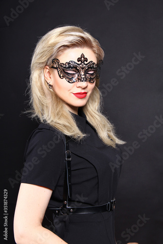 Portrait of a blonde girl in a beautiful lace mask on her face
