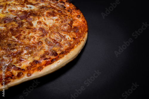 Half pizza on a black background with empty space  top view. Copy space