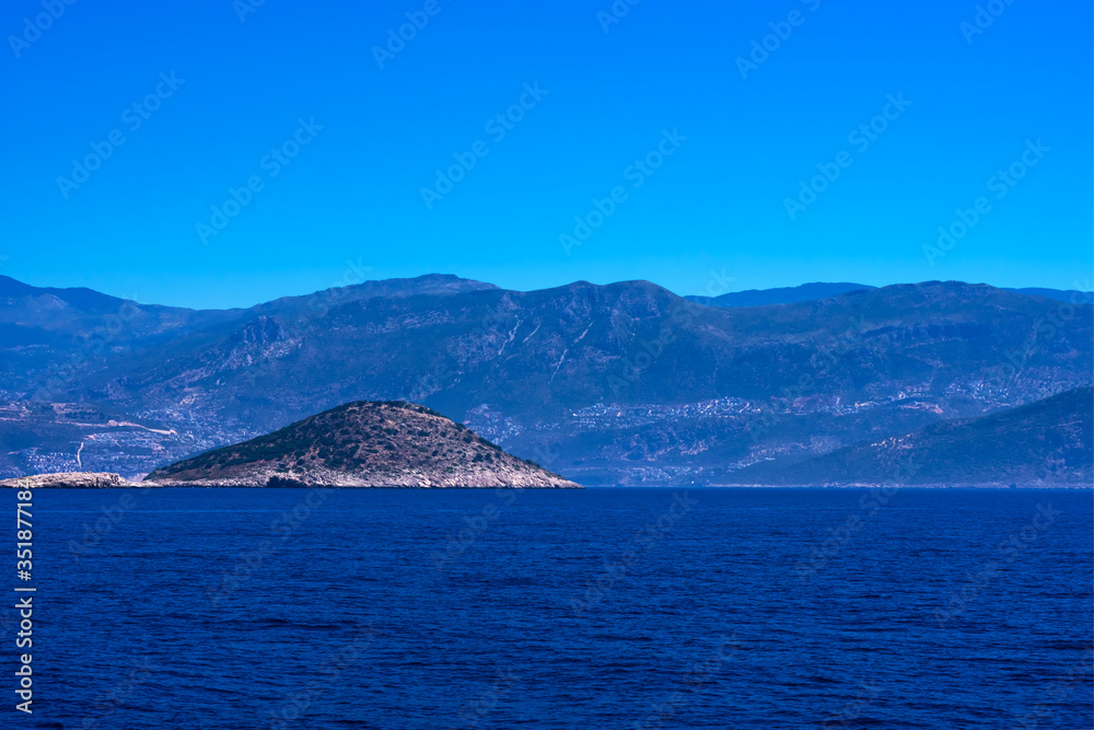 View of calm Mediterranean sea with  mountain, rocky islands. Seascape with montains and blue water