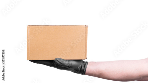 Male hand in a disposable black glove holds a cardboard box - safe delivery of goods, isolate on a white background, copy space © Stanislav Ostranitsa