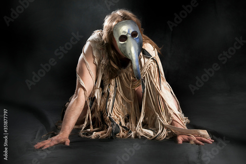 A man in rags and a plague mask photo