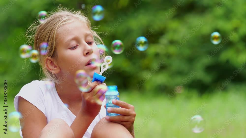 Girl playing with soap bubbles outdoor. Slow motion. Girl playing with soap bubbles outdoor. Slow motion.