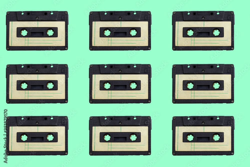 Fototapeta premium vintage audio cassettes pattern on a green background