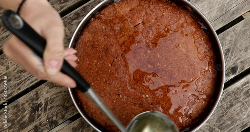 Putting syrup in freshly baked cake