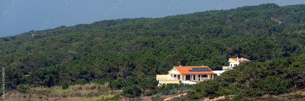Single farmhouse with modern solar panels on a roof in forest