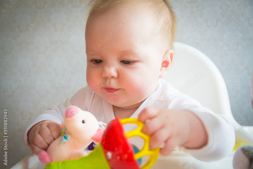 Beautiful little baby in a yellow dress is played with toys Beautiful little baby in a yellow dress is played with toys