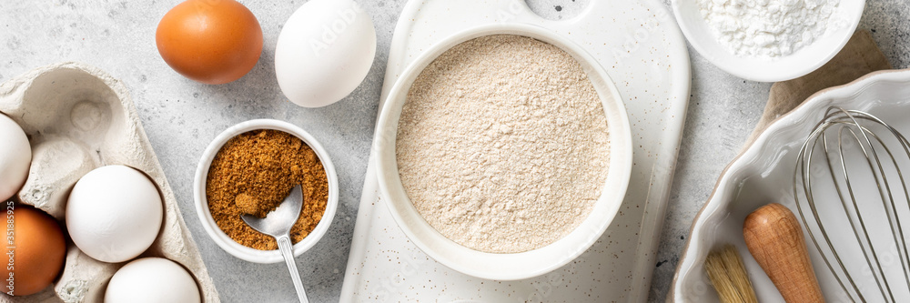 Ingredients for baking on a culinary background. Eggs, flour, cinnamon, sugar, soda on the kitchen table. Concept of preparation for baking. Top view with space for text. Banner Ingredients for baking on a culinary background. Eggs, flour, cinnamon, sugar, soda on the kitchen table. Concept of preparation for baking. Top view with space for text. Banner