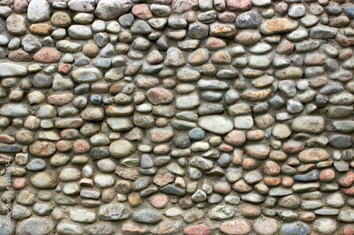 stone wall for the fence of the house from large boulders rubble
