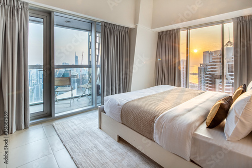 Elegant Bedroom of a High Rise Apartment Overlooking Marina During Sunset