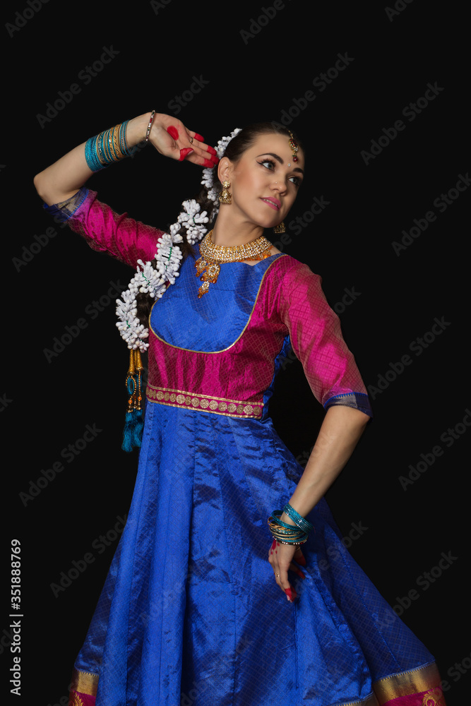 Naklejka premium Girl dancer of Indian dances. A woman in an Indian suit. Portrait on a black background.