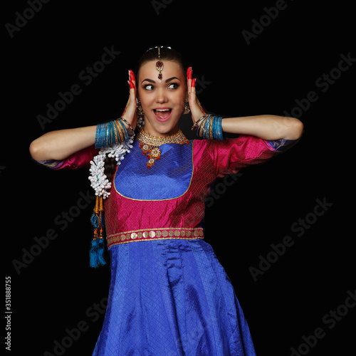 Girl dancer of Indian dances. A woman in an Indian suit. Portrait on a black background. photo
