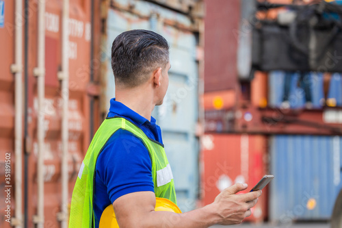 Engineer man uses mobile phone, Industrial worker using mobile smartphone in industry containers cargo