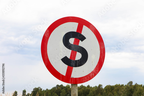 Dont stop traffic sign symbol. Red metal red s cross with circle with sky and trees background
 photo