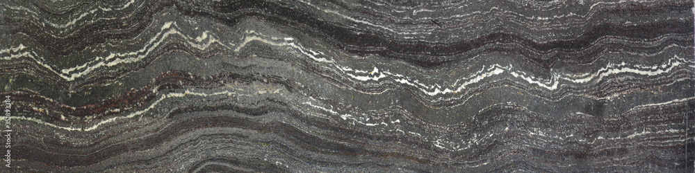 Naklejka premium The rock is Jespilite. Layers and levels on the surface of gray stone