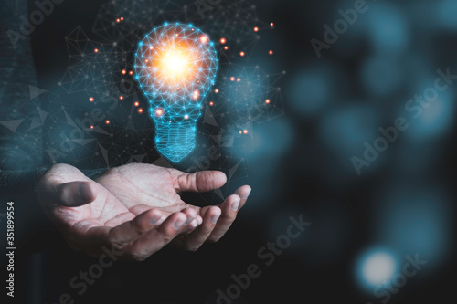 Hand holding the virtual light bulb with brain. Creative new business idea concept. photo